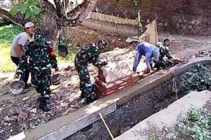 babinsa Koramil Mandirancan saat membantu warga membangun saluran irigasi.